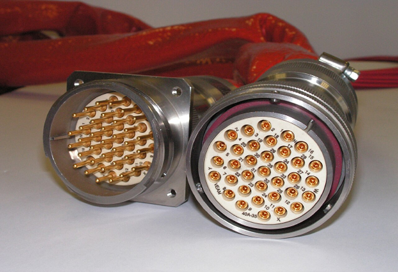 A high-pin-count rugged circular receptacle with gold pins beside its mating plug with coupling ring